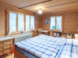 A wooden-paneled room with a bed, a desk, and a chair. - Vacation home Lorenz by Interhome (Flüeli-Ranft)