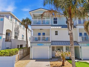 A multi-story residential building with balconies, a garage, and a sign indicating 'Endless Summer.' - Luxe Beach Retreat | Pool • Arcade • Walk to Beach (Jacksonville Beach)