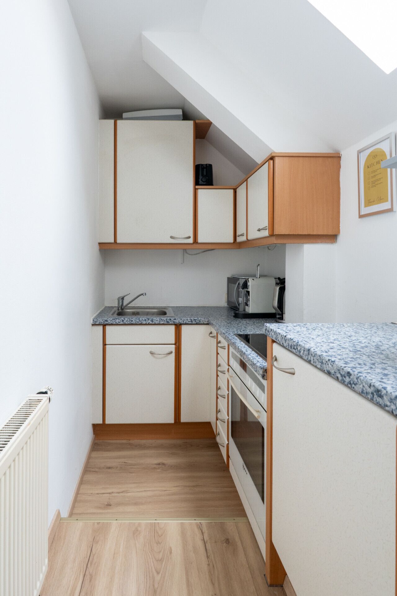 A compact kitchen with a built-in oven, a microwave, and a sink.