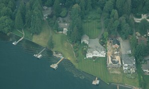 An aerial view of a residential area with houses, a dock, and a body of water.