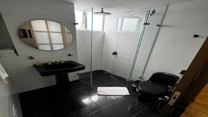A modern bathroom with a black sink, a mirror, a glass shower enclosure, and a toilet. - Lourdes Executive Suites 201 (Bogotá)