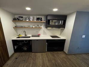 A compact kitchen with a sink, a microwave, and a small dishwasher. - Lourdes Executive Suites 201 (Bogotá)
