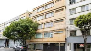 A multi-story building with a flat facade, large windows, and a parking area in front. - Lourdes Executive Suites 201 (Bogotá)
