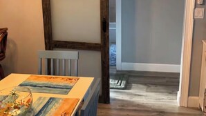 Un comedor con una mesa, sillas y un cuadro.