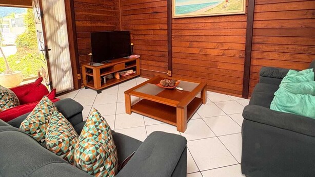 Een gezellige woonkamer met een bank, een salontafel en een televisie.