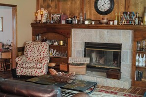 A cozy living room with a fireplace, a clock, and a 'Welcome' sign. - Private Orchard Estate Near KC - World Cup Stay (Kansas City)