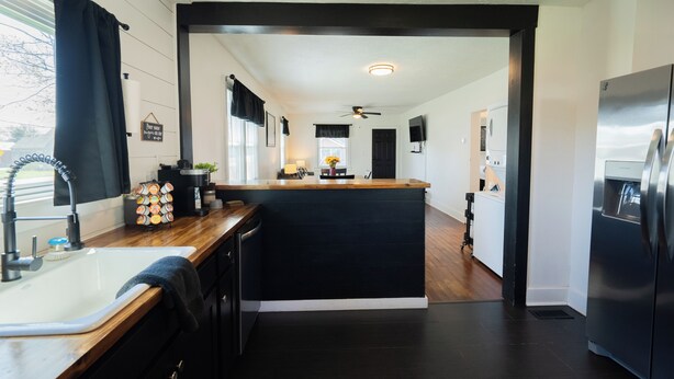 A modern kitchen with a central island, a built-in sink, and a stainless steel refrigerator. - The Bungalow On Fife only 11 minutes from WEC (Wilmington)