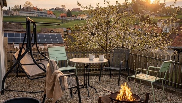 An outdoor patio with a fire pit, seating area, and solar panels in the background.