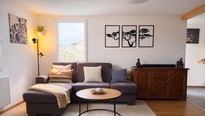 A living room with a sofa, a coffee table, a cabinet, and wall art.