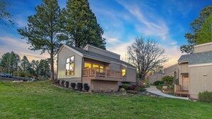 A modern two-story house with a balcony, a covered porch, and a well-maintained lawn. - Golf villa located in Continental Country Club (Flagstaff)
