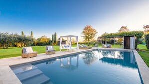 Ein Schwimmbecken mit Liegestühlen und einer Pergola.