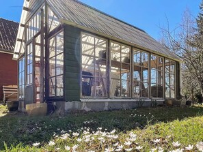 Ein Wintergarten mit großen Fenstern, einem Metall-Dach und einer Holzkonstruktion.