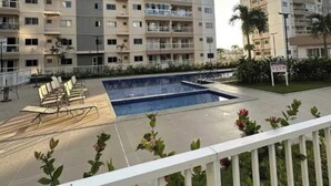 A multi-story residential building with balconies, a swimming pool, and outdoor seating. - Apartment Prox.As Aruna and Atalaia beaches and airport 5 minutes from the apartment. (Aracaju)