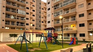 A multi-story residential building with a playground in the courtyard. - Apartment Prox.As Aruna and Atalaia beaches and airport 5 minutes from the apartment. (Aracaju)