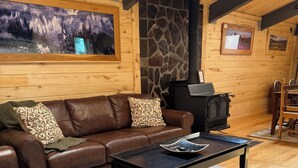 A cozy living room with a brown leather sofa, a black coffee table, and a stone fireplace. - Box Canyon / Downtown Ouray / 2BR / Hot Springs / AC (Ouray)