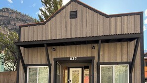 A building with a number '837' above the entrance, a brick lower section, and large windows. - Box Canyon / Downtown Ouray / 2BR / Hot Springs / AC (Ouray)