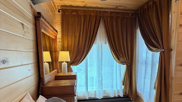 A wooden cabin room with two beds, a nightstand with lamps, and a window with curtains. - Box Canyon / Downtown Ouray / 2BR / Hot Springs / AC (Ouray)