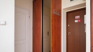 Ein Hotelzimmer-Eingang mit einer Schiebetür, einer Holztür mit einem Schild und einer Fußmatte.