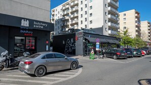 Ein Gebäude mit einem Schild für ‚Fleischerei & Wein‘ und einem Wandgemälde an der Seite.