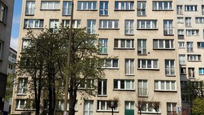 Un immeuble à plusieurs étages, doté de nombreuses fenêtres, de balcons et d’un lampadaire.