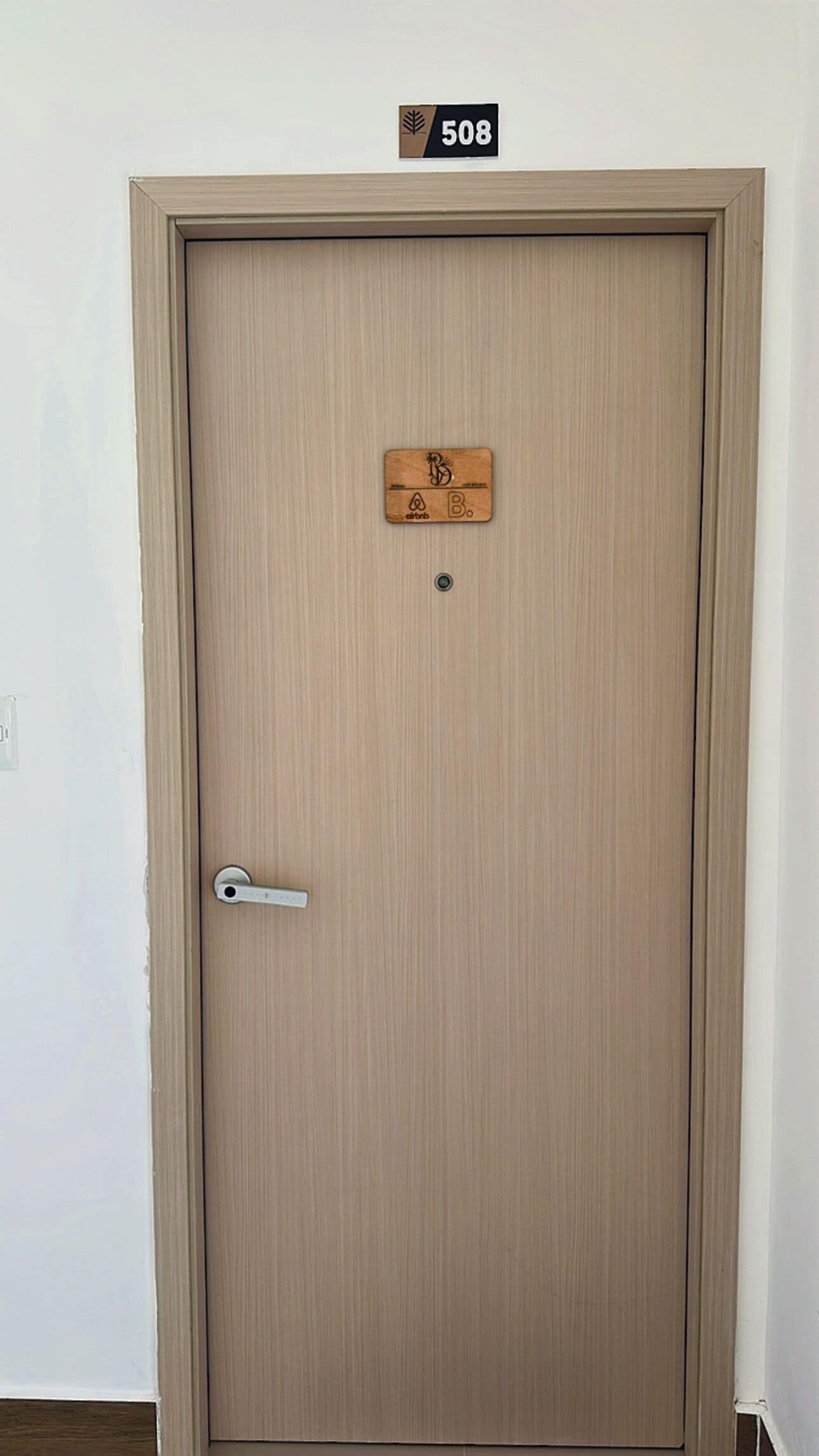 Una porta tancada amb una placa indicant l'habitació 508, una clau i un pom de porta.