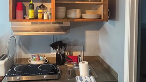 A kitchen with wooden cabinets, a stove, a sink, and a countertop.