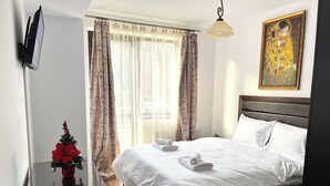 Une chambre d’hôtel avec un lit, un téléviseur à écran plat, un sapin de Noël et un tableau au mur.