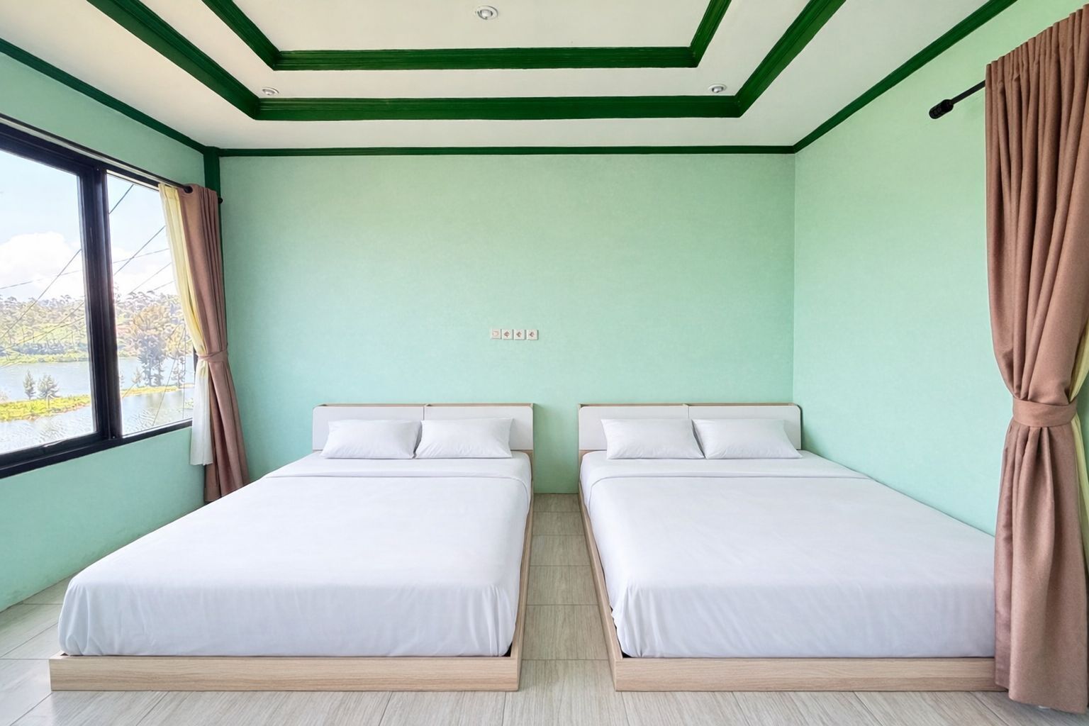 Une chambre avec deux lits, une fenêtre avec des rideaux et une vue sur un paysage.