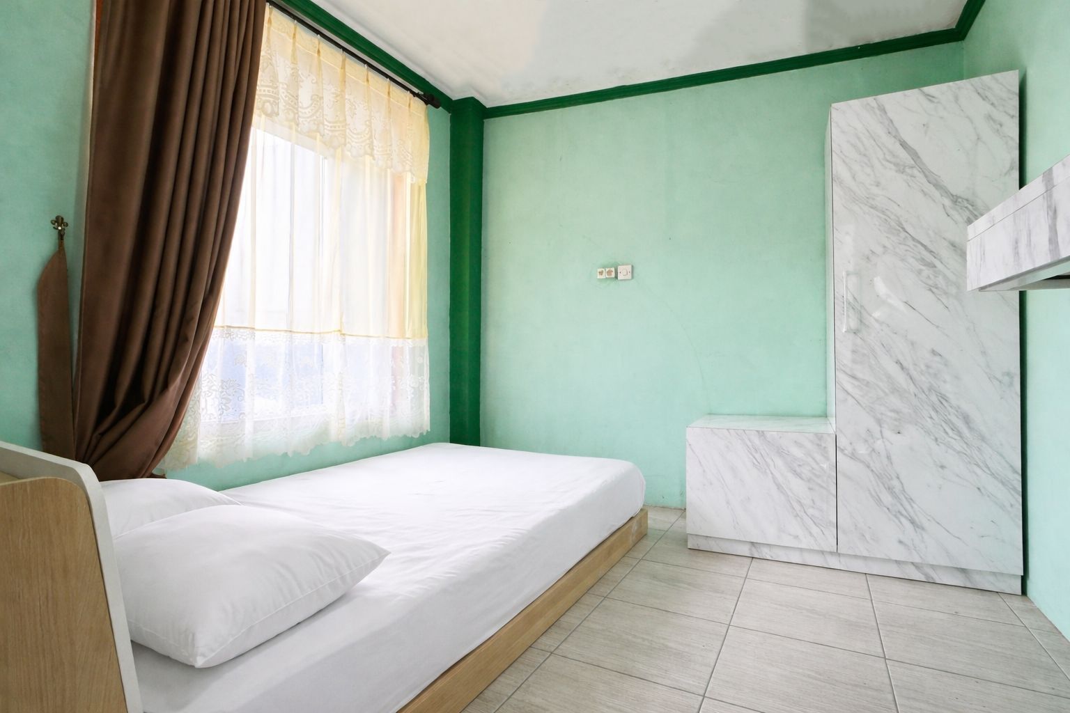 Une pièce avec un lit, une fenêtre avec des rideaux, un mur en marbre et un mur vert.