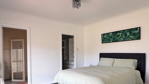Quarto com cama, armário e porta que dá para outro cômodo.