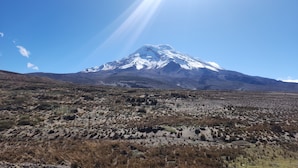 A mountain with a snow-capped peak, a clear sky, and a dry, rocky landscape. - Exclusive tiny house facing Chimborazo at 4000 msnm (Chimborazo)