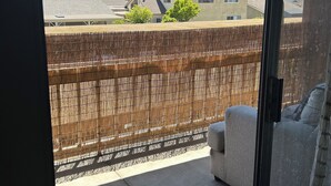 A balcony with a view of a residential area, a wooden fence, and a sofa. - Huntington Beach Condo (Huntington Beach)