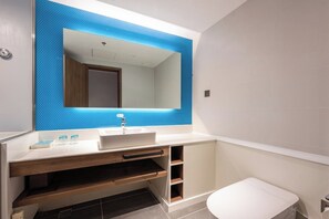 A modern bathroom with a white sink, a mirror with a blue accent, and a white toilet. - Holiday Inn Express Xinji City Center an IHG Hotel (Shijiazhuang)