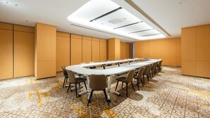 A conference room with a long table, chairs, and a patterned floor. - Holiday Inn Express Xinji City Center an IHG Hotel (Shijiazhuang)