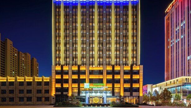A Holiday Inn Express building with a prominent sign, multiple floors, and a well-lit facade. - Holiday Inn Express Xinji City Center an IHG Hotel (Shijiazhuang)