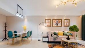 A modern living room with a dining area, a sofa, a coffee table, and a large plant.