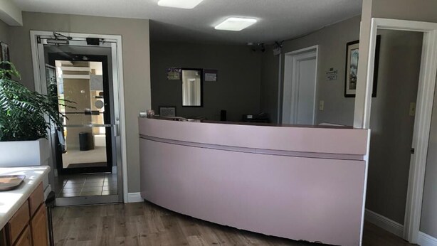 Una cocina con encimera curva, suelo de madera y una puerta que da a otra habitación.