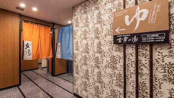A hallway with a sign indicating the Grand Spa 'Genyo' and a women's spa.
