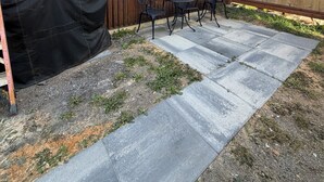 Ein Garten mit Metallzaun, Grill und Gartenmöbeln.