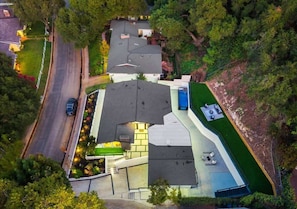 An aerial view of a residential property with a sloped roof, a swimming pool, and a well-maintained lawn. - Near LA Hollywood Garaged Parking Fast WiFi Pool (Los Angeles)
