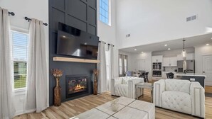 A modern living room with a fireplace, a television, and a sofa. - Fort Haven Near Fort Campbell, Spacious 4BR Retreat (Clarksville)
