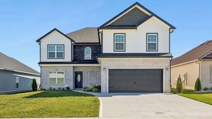 A two-story house with a garage, a front door, and a small front yard.
