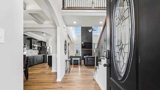 A spacious interior with a kitchen, dining area, and a staircase leading to an upper level.