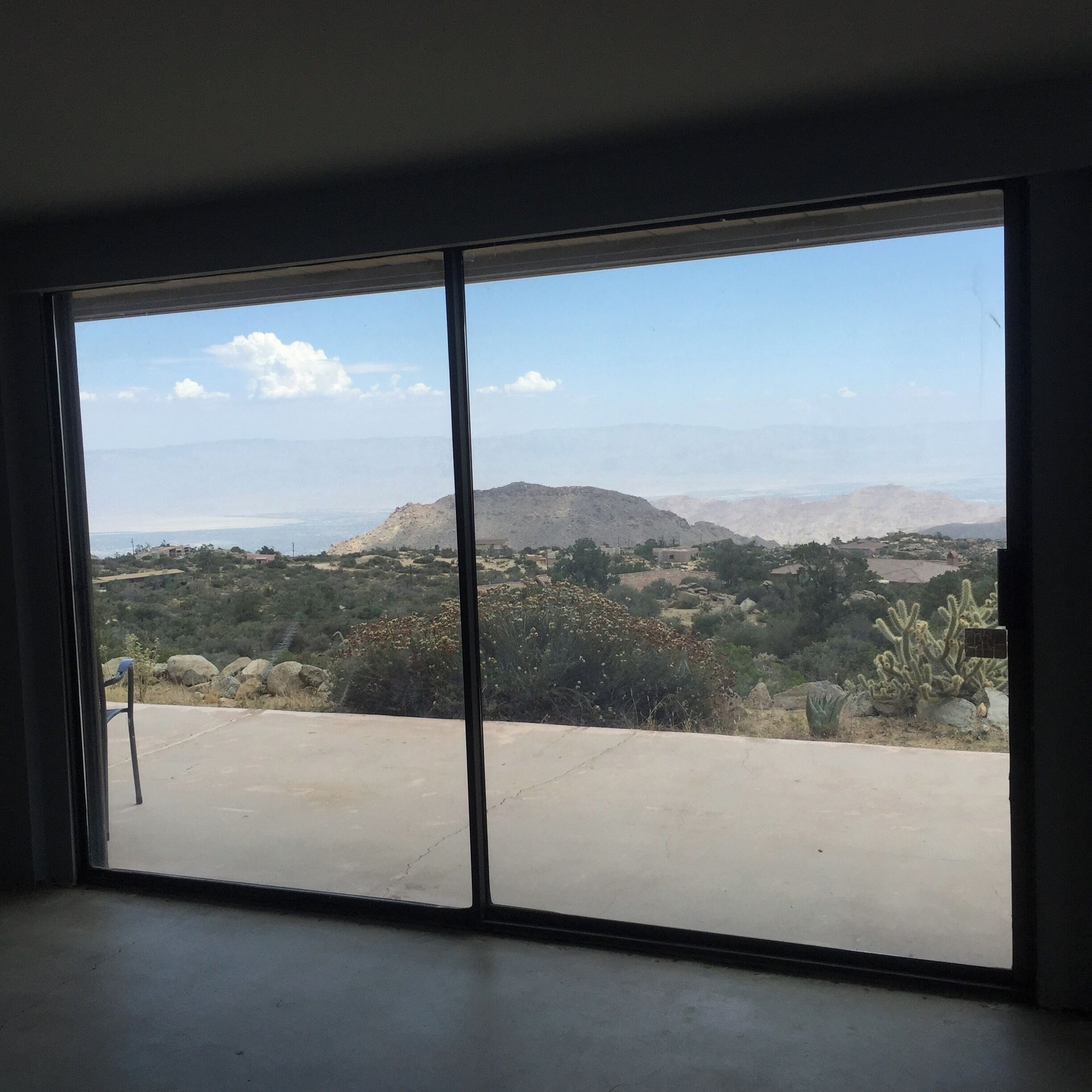 Ein Zimmer mit einer großen Schiebeglastür, die einen Blick auf eine Berglandschaft freigibt.