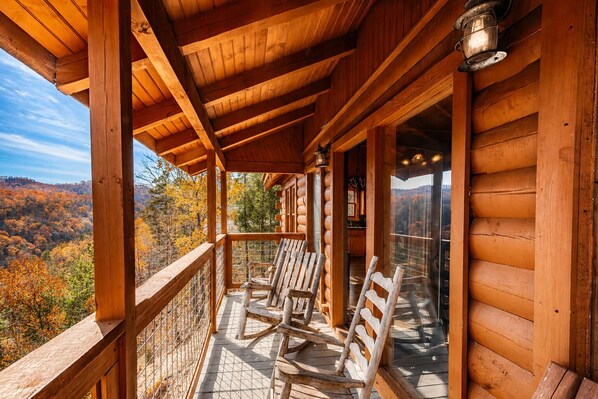 A wooden cabin with a balcony, wooden chairs, and a view of autumn foliage. - NEW LISTING special pricing. Amazing views+Hot Tub+Games and Location! (Sevierville)