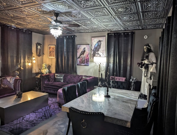 Una habitación con un techo decorado con diseños intrincados, una araña y una mesa con un jarrón y una estatua.