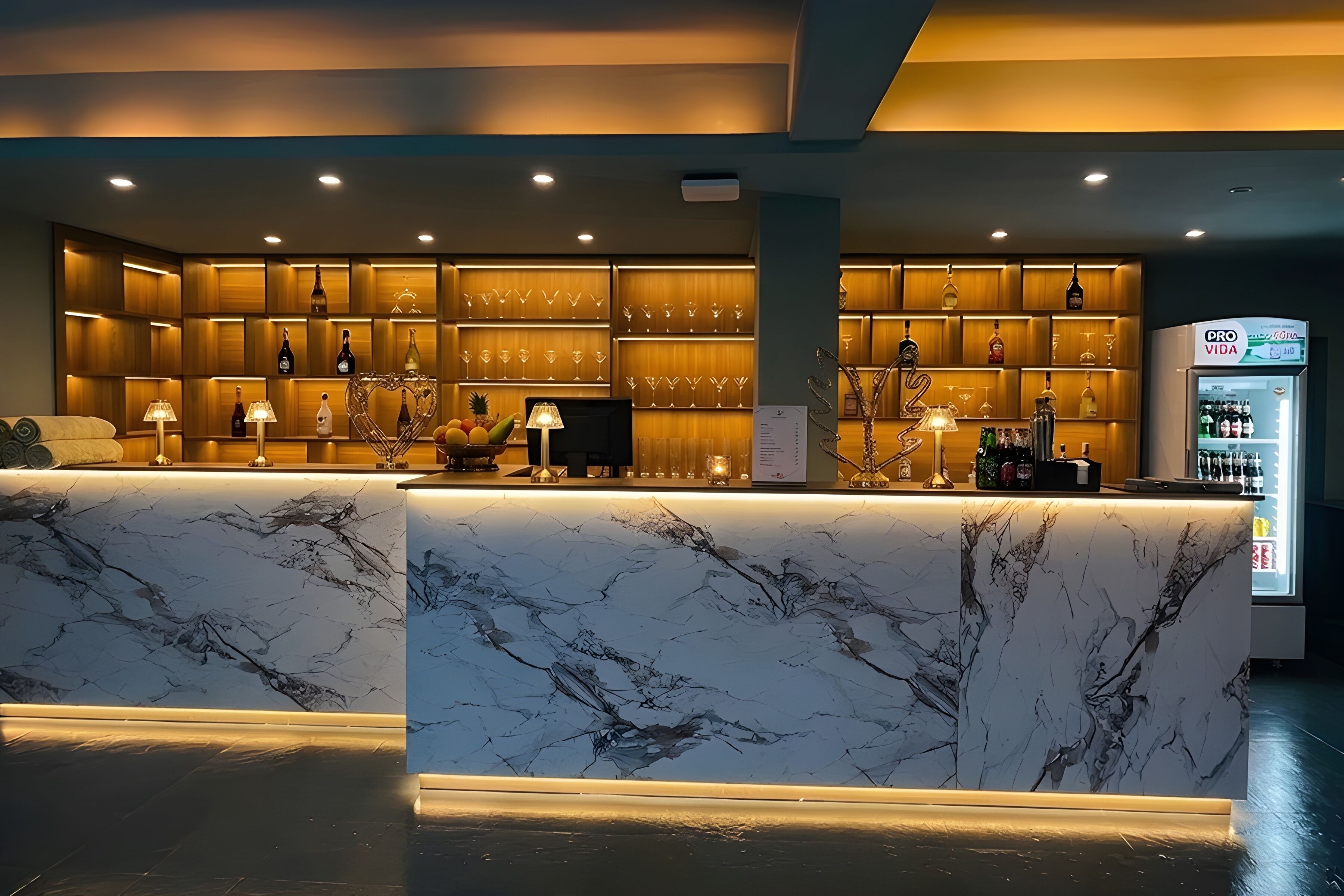 Zona de bar con mostradores de mármol, estanterías con botellas y vasos, y un refrigerador con el rótulo 'DRO VIDA'.