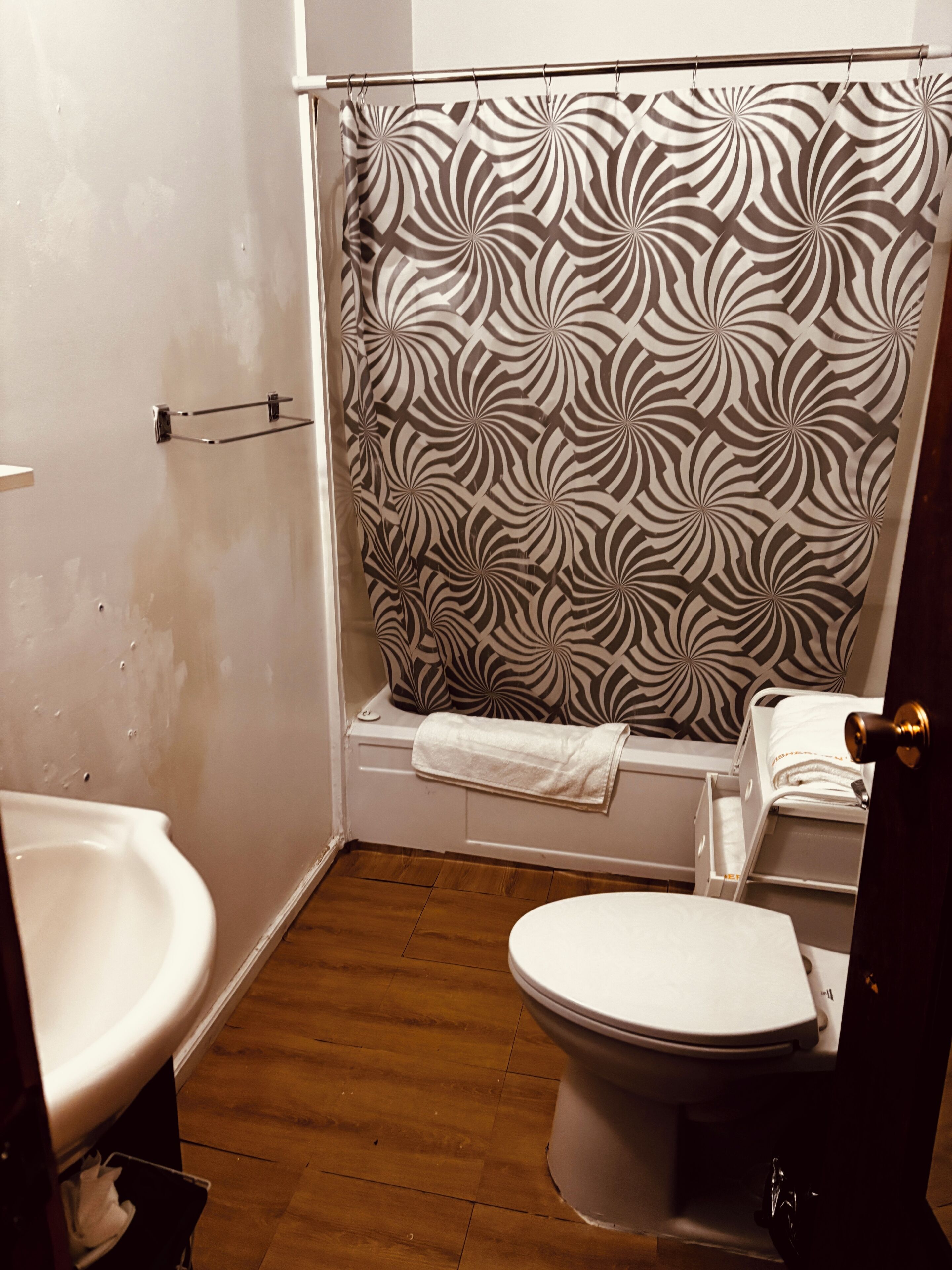 A bathroom with a shower curtain, a toilet, and a sink.