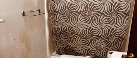A bathroom with a shower curtain, a toilet, and a sink.