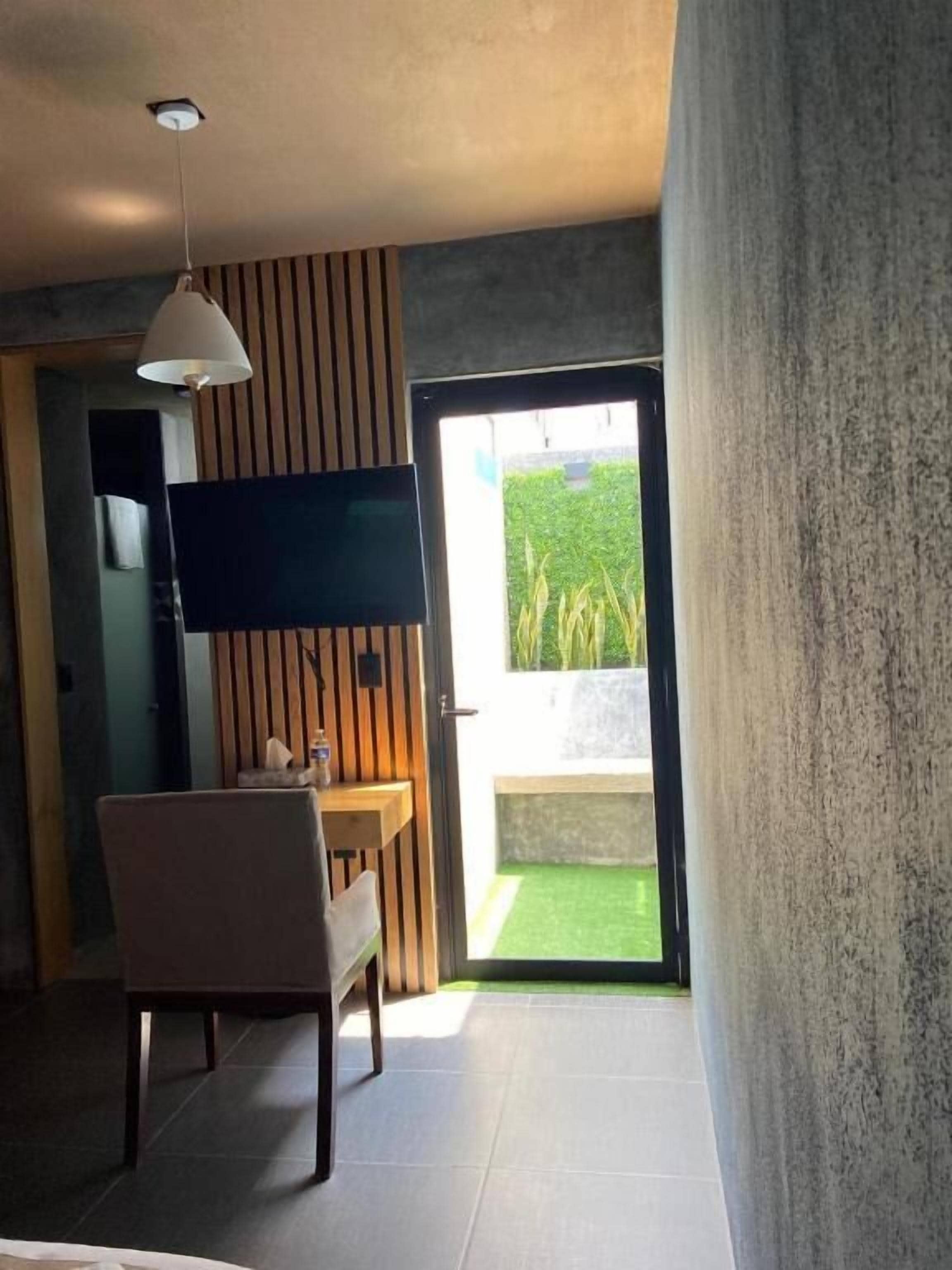 Una habitación moderna con televisión de pantalla plana, una mesa de comedor y una silla.